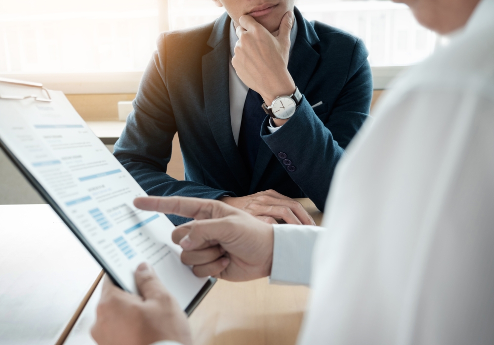 business man interviewer looking skeptical while listening to an asian female interview
